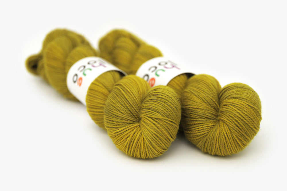 semisolid hand dyed caper (olive yellow green) merino sock yarn