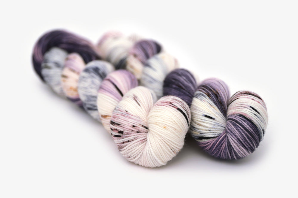 speckled hand dyed dark purple lilac white merino sock yarn