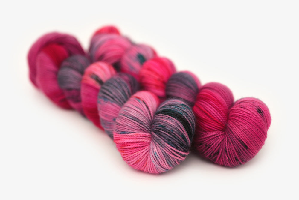 speckled hand dyed hot pink purple aqua merino sock yarn