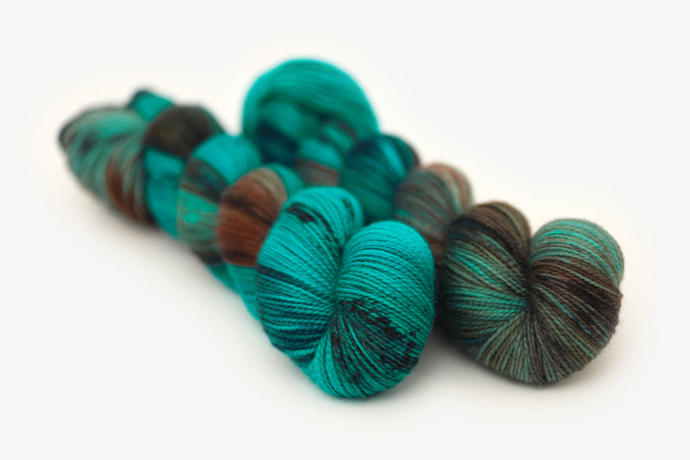 speckled hand dyed teal aqua dark purple merino sock yarn