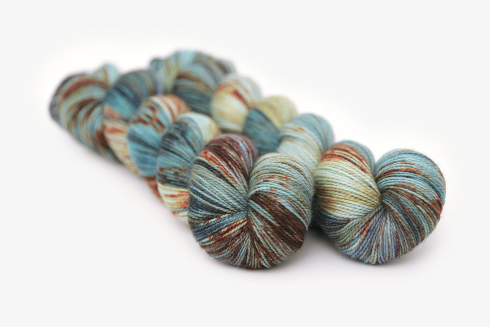 speckled hand dyed blue rust orange sage merino sock yarn