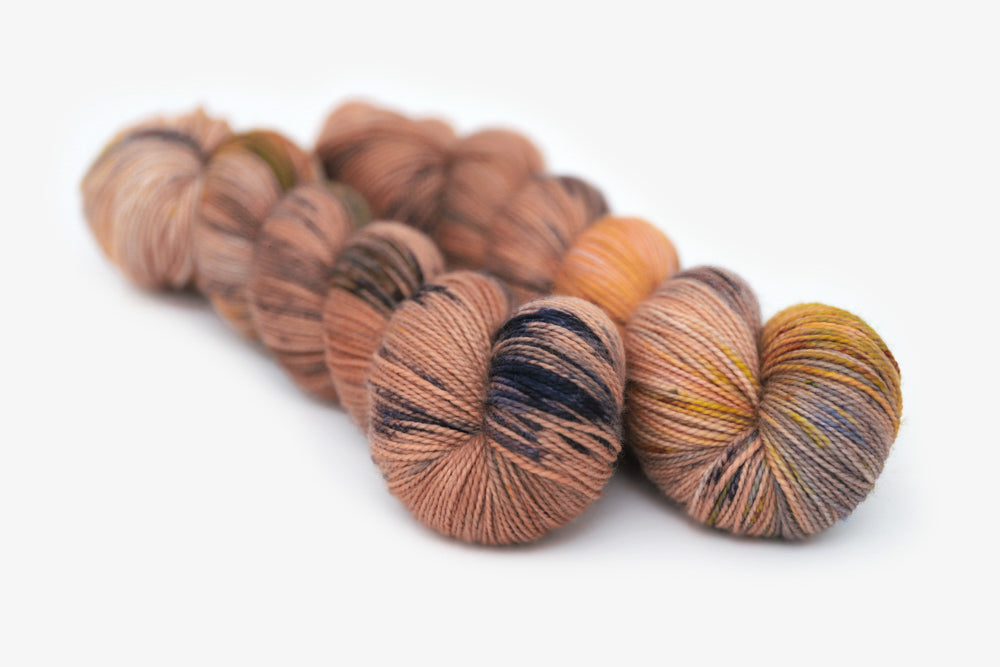 speckled hand dyed dusty pink yellow blue tan merino sock yarn