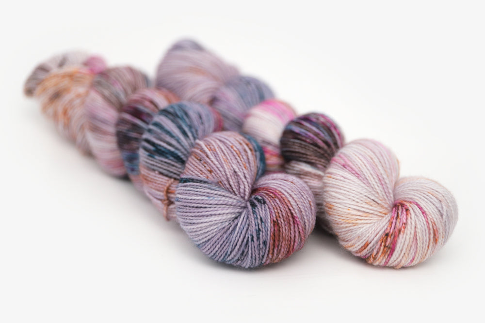 speckled hand dyed lilac teal magenta brown merino sock yarn