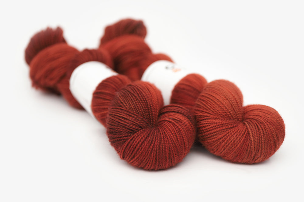 semisolid hand dyed dark rust red merino sock yarn