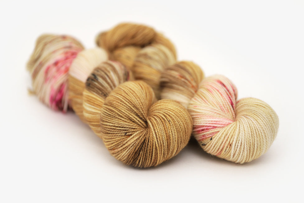 speckled hand dyed gold ochre fuchsia merino sock yarn