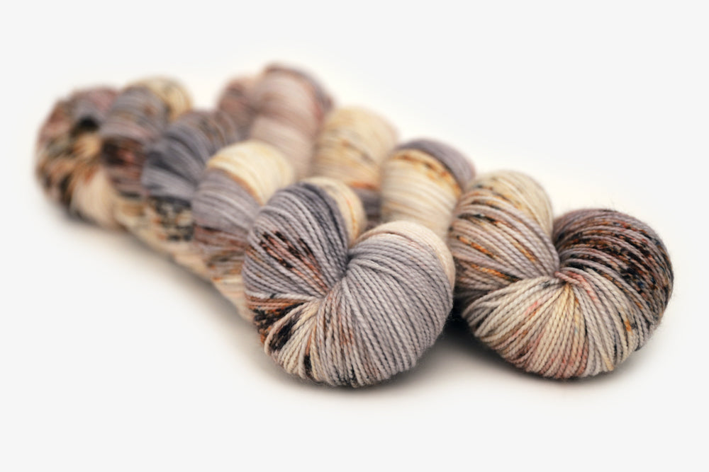 speckled hand dyed warm white gray brown maroon merino sock yarn