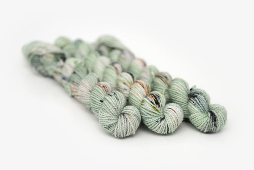 speckled hand dyed pale green sage peach merino sock mini yarn