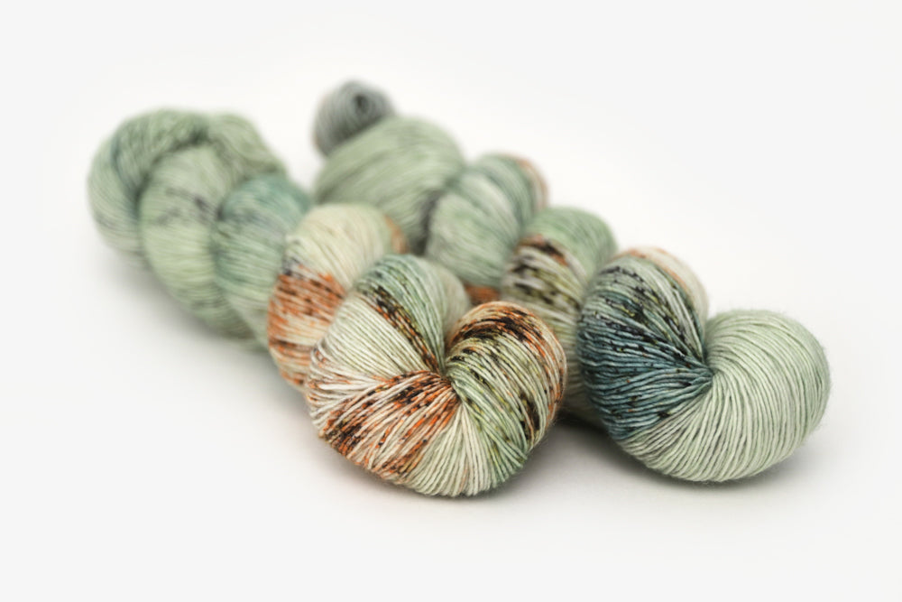 speckled hand dyed pale green sage peach single sock yarn